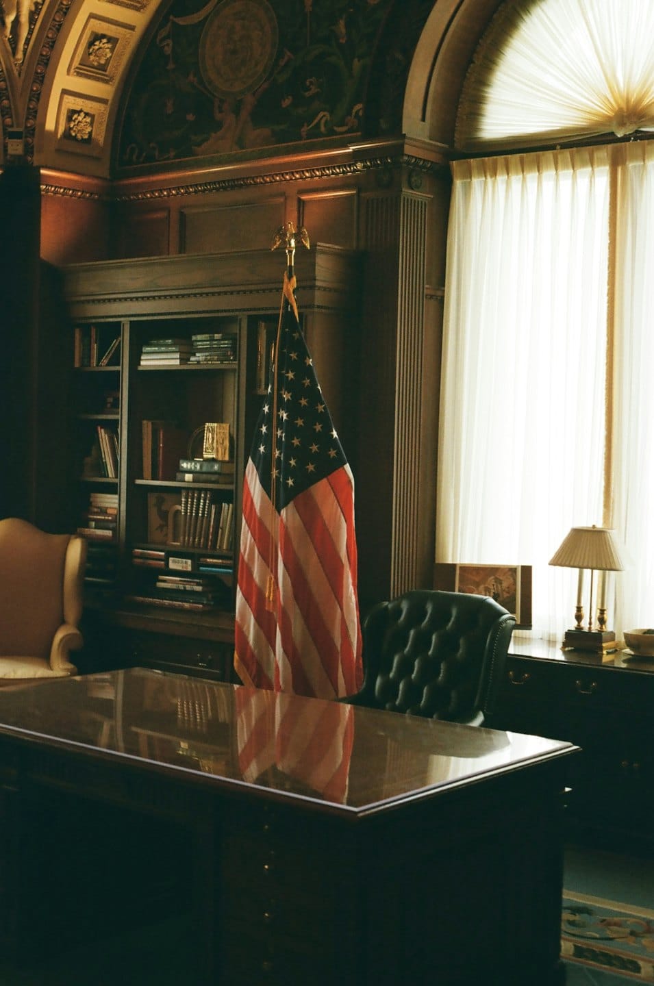 A formal office with a wooden desk and leather chair.